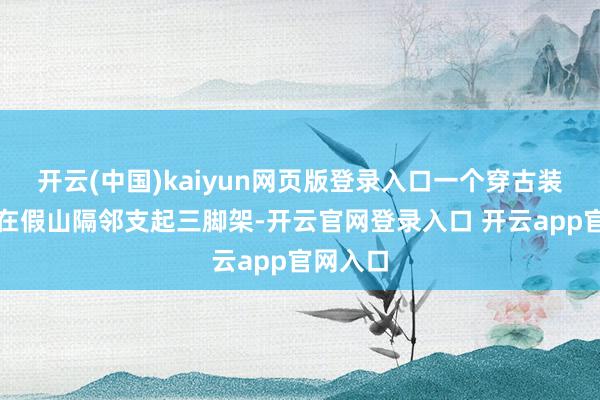 开云(中国)kaiyun网页版登录入口一个穿古装的女孩在假山隔邻支起三脚架-开云官网登录入口 开云app官网入口